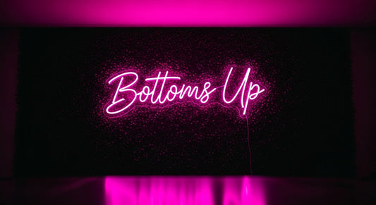 Bottoms Up Neon Sign - pink neon on grass background