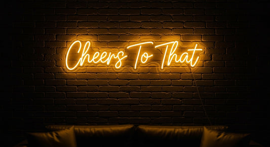 Cheers To That Neon Sign - yellow neon on brick background