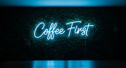 Coffee First Neon Sign - ice blue neon on grass background
